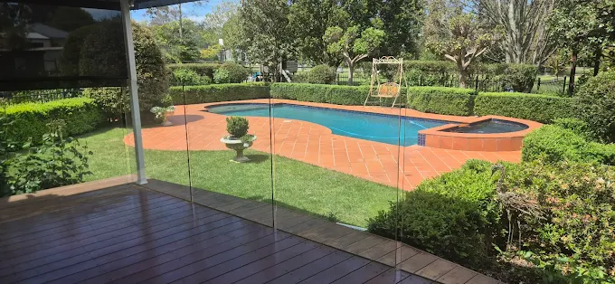 Pool area with glass fencing and landscaping